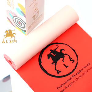 A person outdoors aiming a wooden gulel, or slingshot, which is fitted with the dual color flat latex band, demonstrating its smooth elasticity and flexible performance.